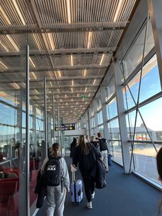 people are walking through an airport with their luggage