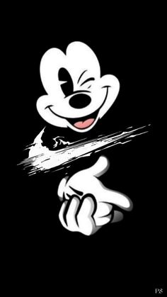 a mickey mouse holding onto a stick with his tongue out and eyes wide open in the dark