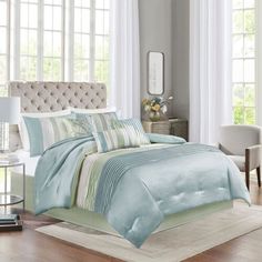 a bed with blue and green comforters in a bedroom