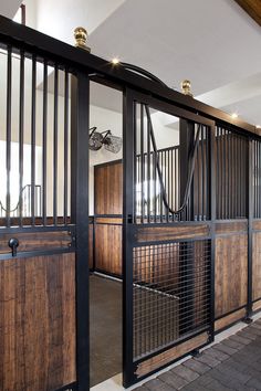 the inside of a building with wooden doors and metal bars on each door, along with brick flooring