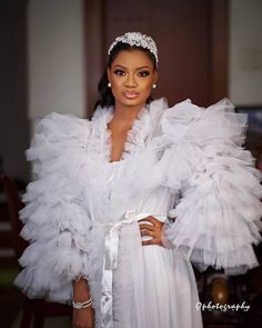 a woman wearing a white dress and headpiece