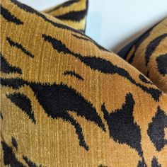 two pillows with black and gold designs on them