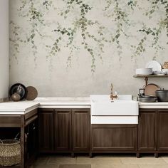 a kitchen area with sink, cabinets and wallpaper on the back wall in front of it