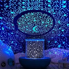 a room with stars and moon lights on the ceiling is lit up by blue light