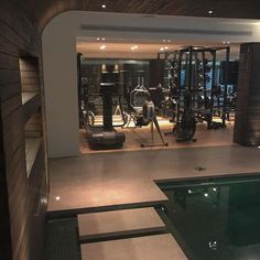 an indoor gym with treadmills, exercise machines and swimming pool in the foreground