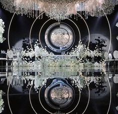 a black and white photo with chandeliers hanging from it's ceiling, reflecting in the water