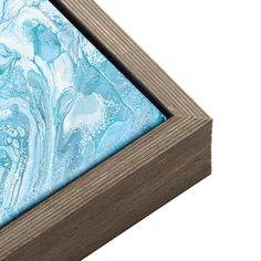 an abstract painting with blue and white colors in a wooden frame on a white background