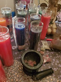 there are many different colored candles on the table