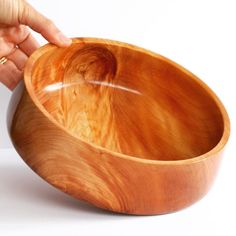 a person is holding a wooden bowl in their hand