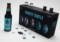 a bottle of beer next to some buttons and a box with the words thirsty turtle on it