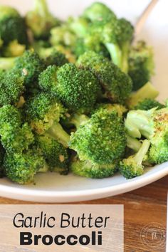 a white plate topped with broccoli on top of a wooden table