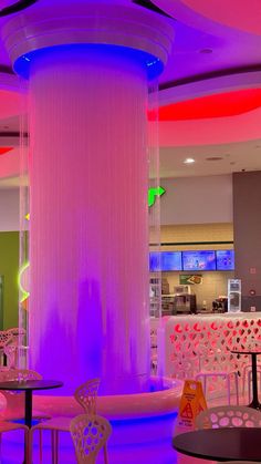 the inside of a restaurant with tables and chairs around a water fountain in the center