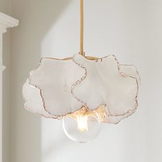 a light fixture hanging from a ceiling with a glass globe in the middle and a white wall behind it