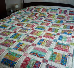 a bed with a colorful quilt on top of it