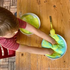 a young boy sitting at a table with a bowl and spoon in front of him