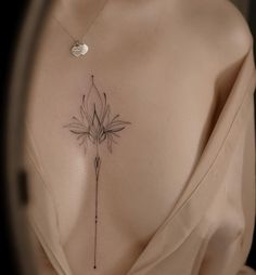 the back of a woman's chest with a flower tattoo on her left side