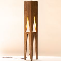 a wooden table lamp with two lights on each side and a cord connected to it