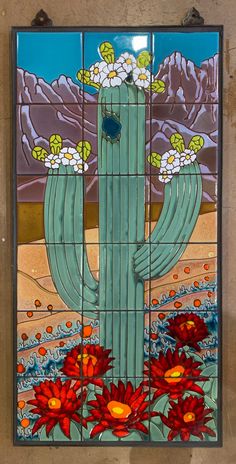 a stained glass window with a cactus and flowers in the desert on it's side