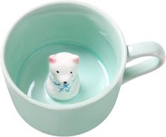 a small white bear sitting inside of a cup