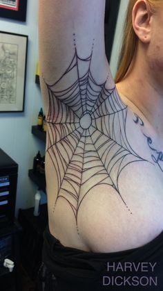 a woman with a spider web tattoo on her arm and shoulder, showing the upper part of her body