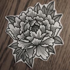 a sticker with an image of a flower in black and white on a wooden surface