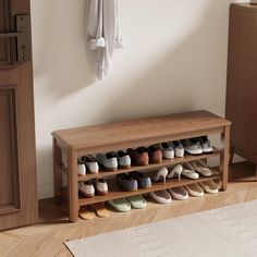 a wooden shoe rack filled with shoes next to a wall mounted coat rack and door