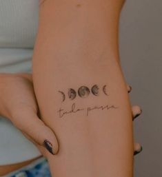 a woman's arm with three phases of the moon tattooed on her left side