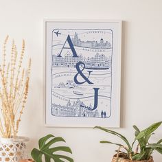 a blue and white art print on a wall next to potted plants