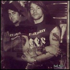 two men standing next to each other with tattoos on their arms