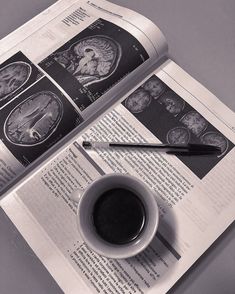 a cup of coffee sitting on top of an open book