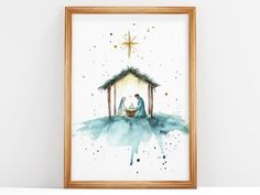 a watercolor painting of a manger scene with a baby jesus in the manger