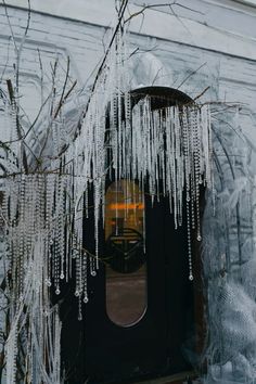 icicles hanging from the side of a building next to a door with a window