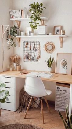 an image of a home office with plants on the desk and shelves above it that are filled with photos