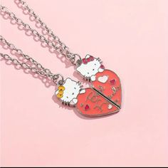 two hello kitty necklaces on a pink background