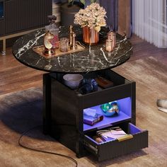 a marble top coffee table with an illuminated drawer underneath it and flowers in vases on the side