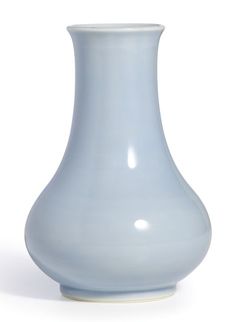 a light blue vase sitting on top of a white table