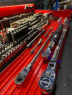 the tools are lined up on the red shelf in the shop for repair and maintenance