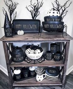 a shelf with black and white halloween decorations on it, including pumpkins, witch hats and other items