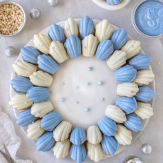 a cake decorated with blue and white icing on a plate next to other desserts