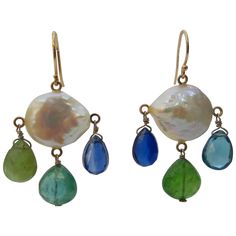 Beautiful pair of multi colored Chandelier earrings by Marina J. This pair is made using all solid 14k Yellow Gold wiring and organic stones. Two large flat coin Pearls with wild iridescence and sheen are used in this pair. One earrings displays striking Blue Kyanite, Green Iolite and Teal Tourmaline faceted Briolettes freely hanging. The other, is made with Blue Kyanite, Green Iolite and radiant London Blue Topaz. The translucency of these stones allow them to flash magnificent hues of blues an Coral Drop Earrings, Topaz Yellow, Cocktail Earrings, White Pearl Earring, Yellow Gold Earrings, Baroque Pearl Earrings, Coin Pearls, White Gold Earrings, Yellow Gold Earring