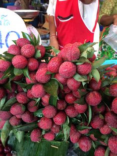 a pile of fresh strawberries sitting on top of a table next to other fruits