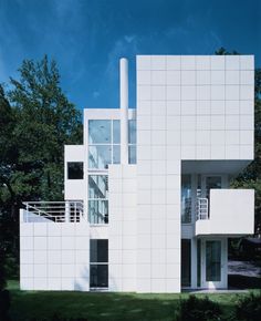 a large white building sitting next to a lush green park