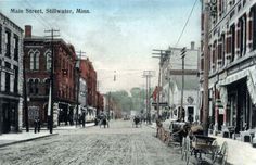 an old photo of a street with horse drawn carriages