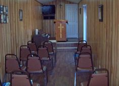 an empty room with chairs and a podium in the center, on which there is a cross