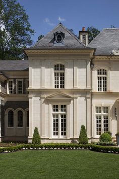 a large white house sitting on top of a lush green field