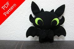 a black stuffed animal with green eyes on a table