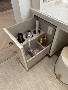 a hair dryer, combs and other items are in the corner of a cabinet