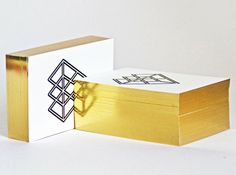 an open box sitting on top of a white table next to a gold foiled object