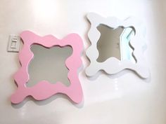 two white and pink mirrors on the wall