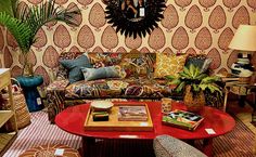 a living room filled with lots of furniture next to a wall covered in patterned walls